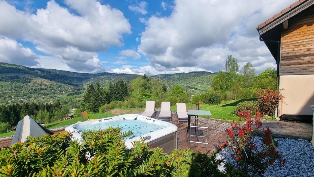 a hot tub on a patio with mountains in the background at Chalet Terejo & spa in Ventron