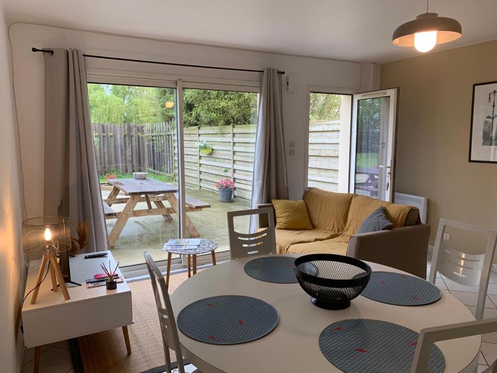 un salon avec une table et un canapé dans l'établissement Gîte du Triskell Le Domaine de Coat Rogan, à Pommerit-Jaudy