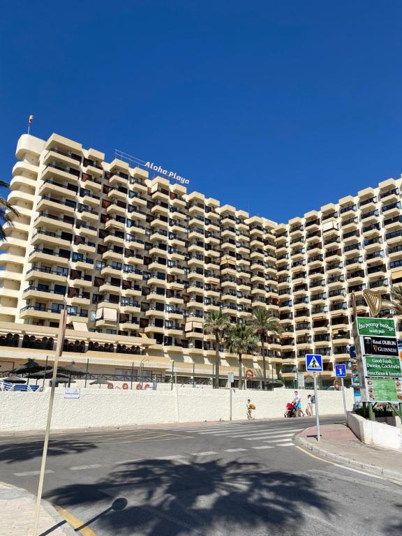 un gran edificio de apartamentos en la playa con una calle en BENALMADENA ALOHA PLAYA BEACH LOFT, en Benalmádena