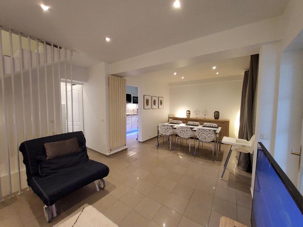 a living room with a chair and a dining room at Charmante villa proche de la gare et de Paris in Les Pavillons-sous-Bois