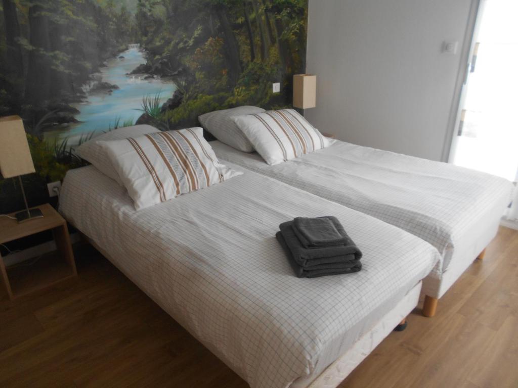 walizkę siedzącą na łóżku w sypialni w obiekcie Résidence l'estrade w mieście Dunkierka