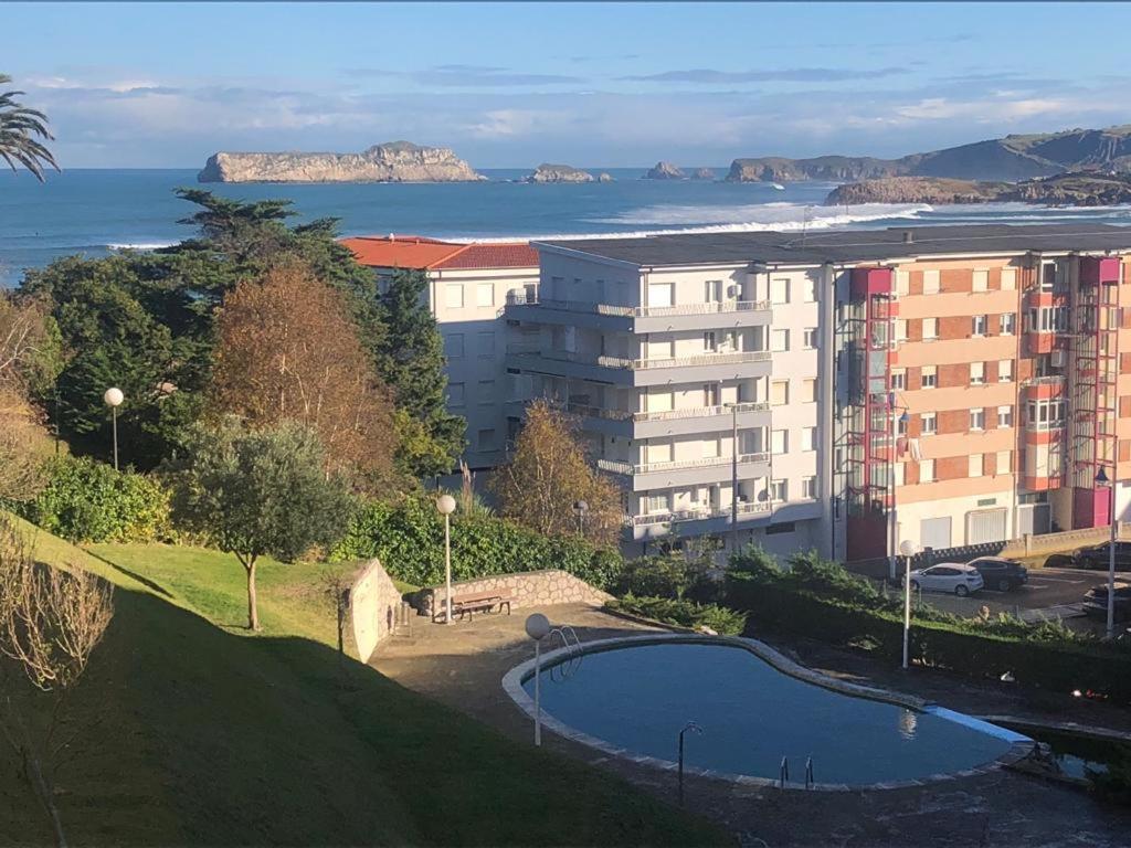 - un bâtiment avec une piscine à côté de l'océan dans l'établissement Apartamento con vistas al mar y piscina II, à Suances