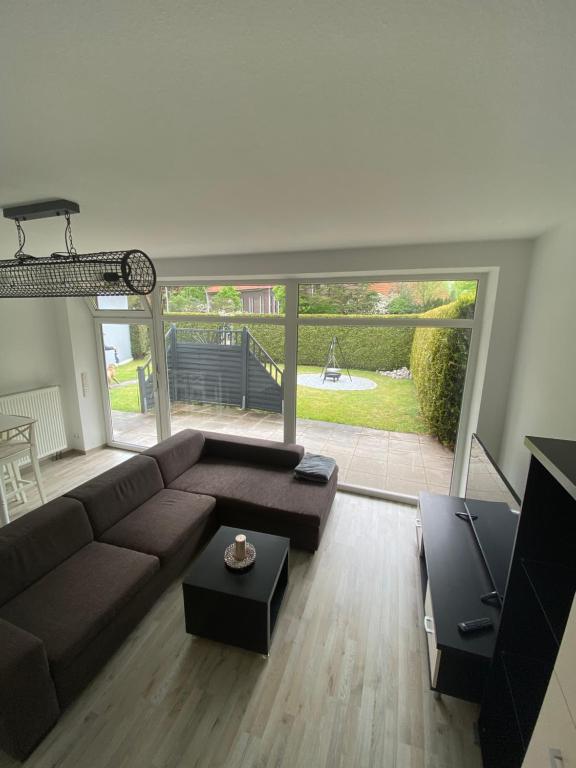 Una sala de estar con un sofá marrón y una mesa. en Ferien- und Monteurwohnung mit großem Garten, en Oldenburg