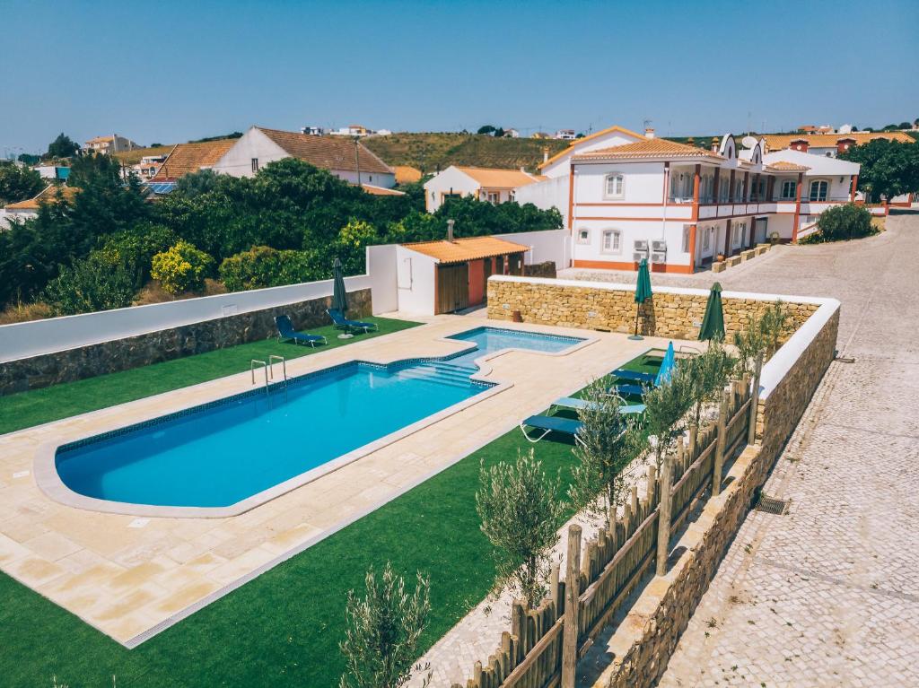 a swimming pool in a yard next to a house at Pátio da Figueira in Torres Vedras