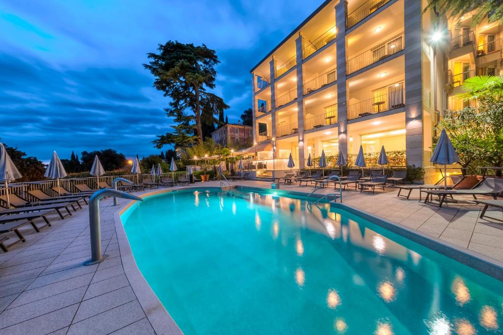 a swimming pool in front of a building at Hotel Excelsior Le Terrazze in Garda