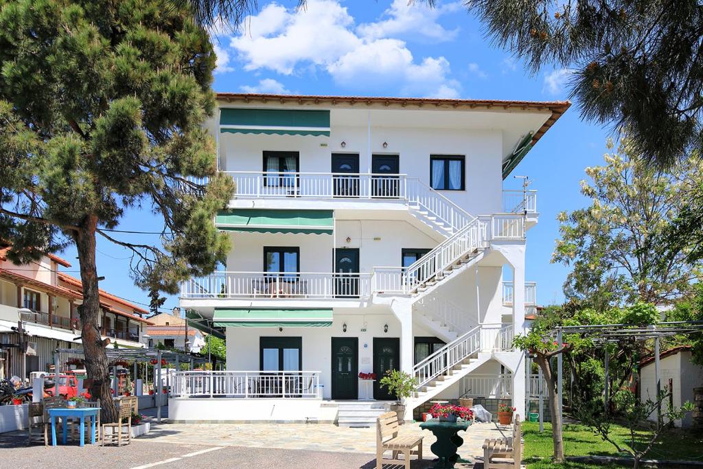 a white building with stairs in front of it at Agapitos Apartments in Nikiti
