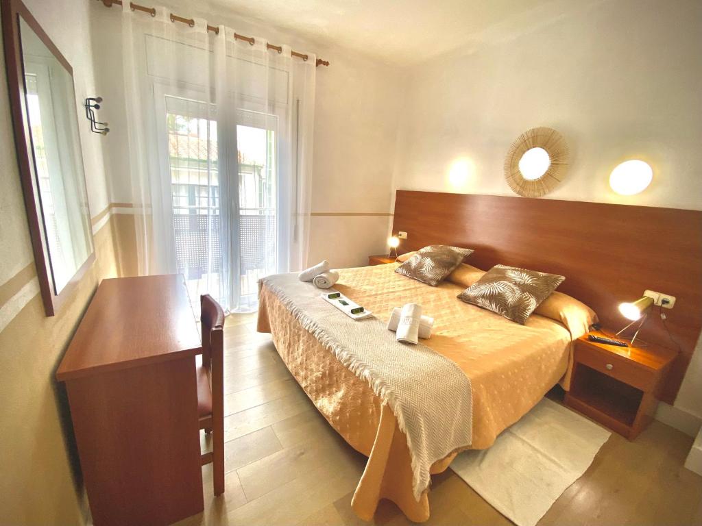 1 dormitorio con 1 cama grande y cabecero de madera en Hotel Montecarlo, en Llafranc