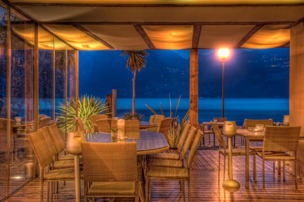 a restaurant with tables and chairs and a view of the ocean at BAIA in Brenzone sul Garda