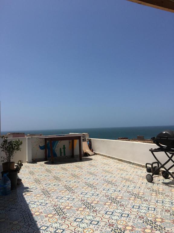 a patio with a table and a view of the ocean at EL Faro Surfstay in Tamri