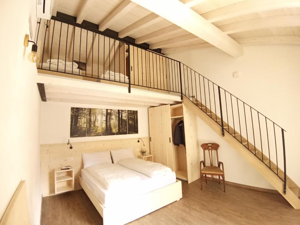 a bedroom with a bed and a staircase at appartamenti Residenza 1928 in Tremosine Sul Garda