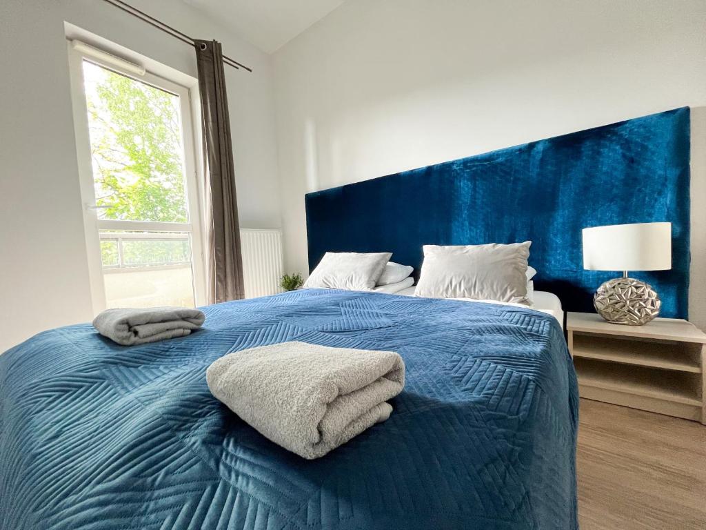 um quarto com uma cama azul com toalhas em Warsaw Inside Apartments em Varsóvia