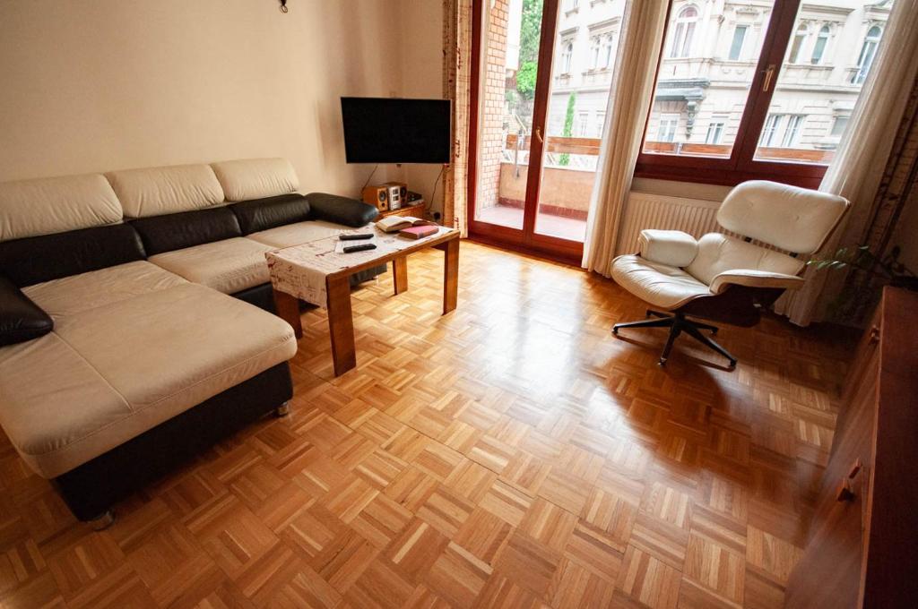 sala de estar con sofá, mesa y silla en Castle Hillside Apartment, en Budapest