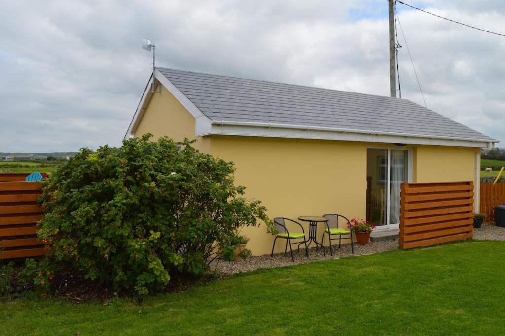 a house with a table and chairs in a yard at The Getaway, Miltown Malbay in Miltown Malbay