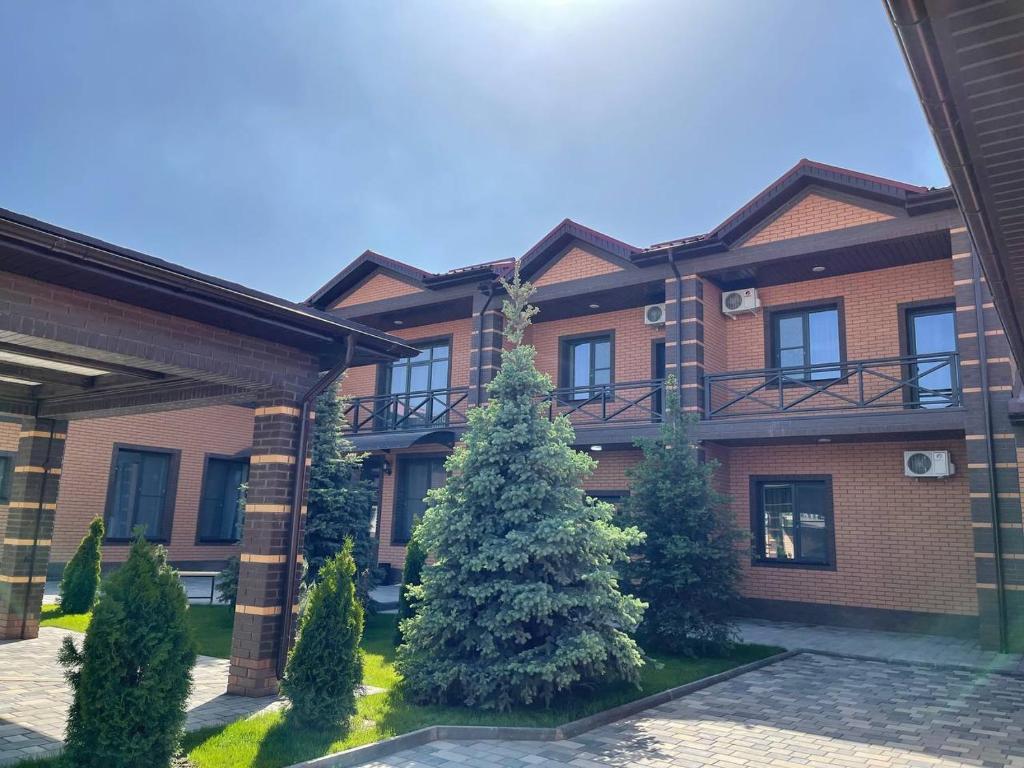 a brick building with a tree in front of it at JETISY COMPLEX in Taraz