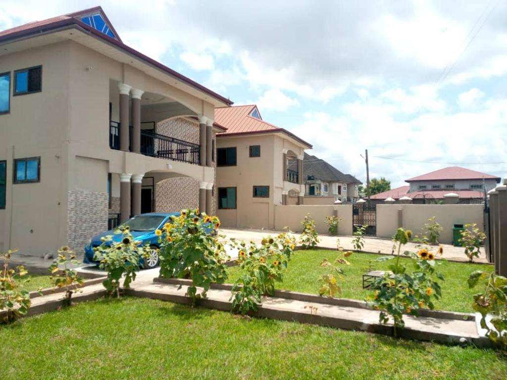 una casa con un jardín delante de ella en Stunning Executive 2 Bedroom Apartment with KING SIZE BED, en Kumasi