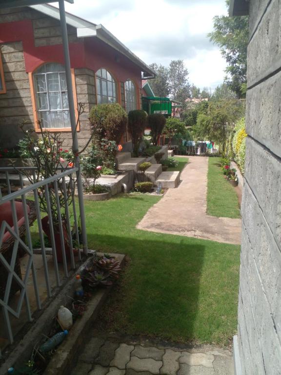 a house with a yard with grass and a fence at 3-bedroom, 2-bedroom, 1-bedroom serenity homes in Langata Rongai