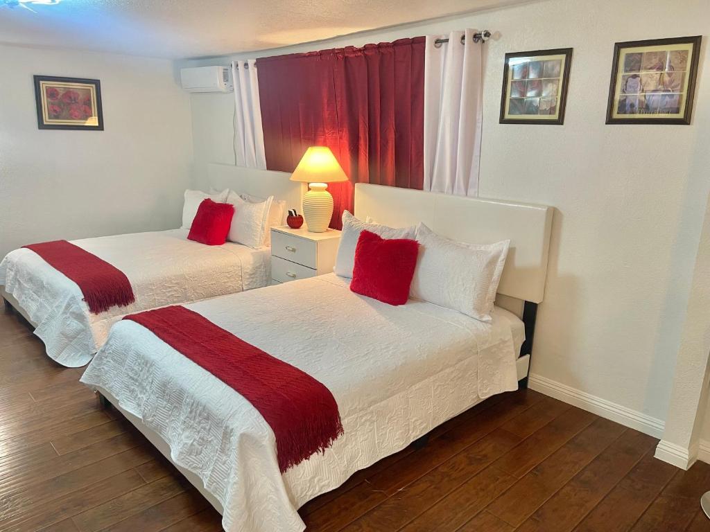 two beds with red pillows in a hotel room at “Beautifull Cozy Studio…With Private Entrance” in Las Vegas