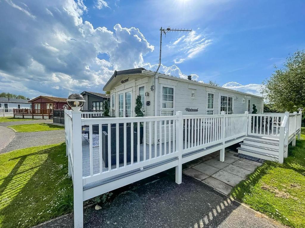 a white house with a white fence at Beautiful Caravan At Manor Park In Hunstanton Beach, Norfolk Ref 23026h in Hunstanton