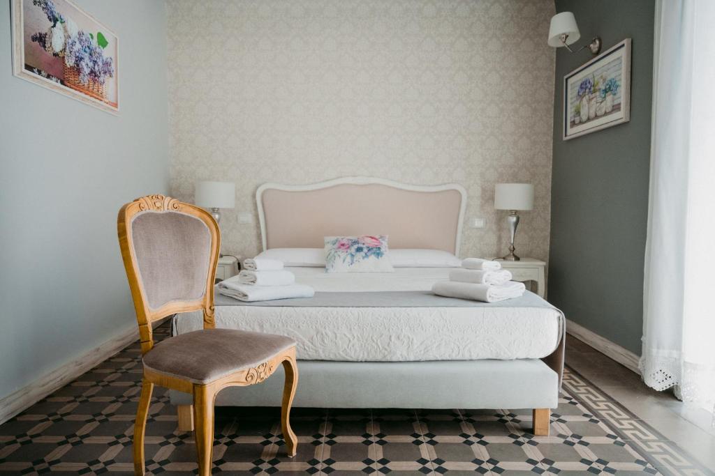 - une chambre avec un lit et une chaise dans l'établissement La Casa di Alma Luxury rooms, à Catane