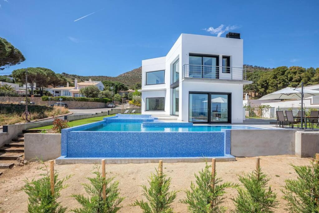 a villa with a swimming pool in front of a house at Sea views in Cap de Creus - Free WIFI - LUMEN HOUSE in Port de la Selva