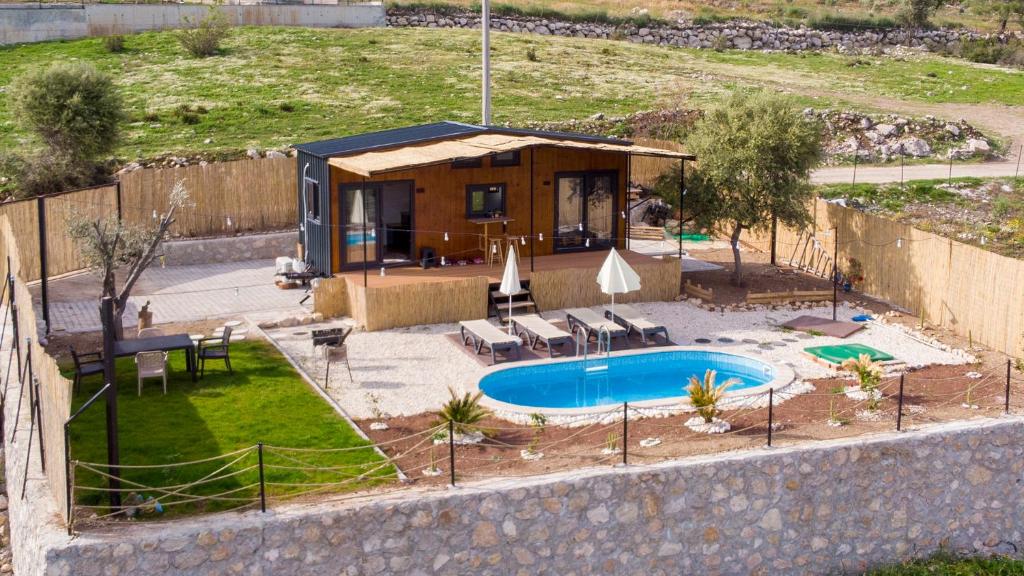 une petite maison avec une piscine en face de celle-ci dans l'établissement Olive Garden Tiny House, à Kumluca