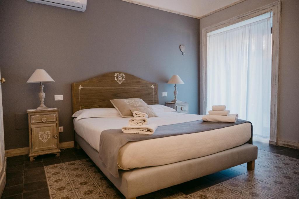 sypialnia z dużym łóżkiem i ręcznikami na nim w obiekcie La Casa di Alma Luxury rooms w Katanii