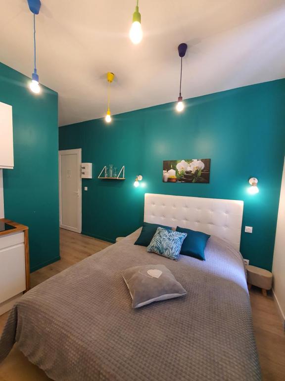 ein Schlafzimmer mit einem großen Bett mit blauer Wand in der Unterkunft "Le Petit Paradis" au Centre Ville d'Oyonnax in Oyonnax