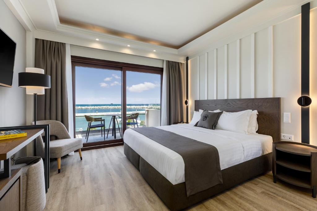 a hotel room with a bed and a view of the ocean at Diverso Platamon, Luxury Hotel & Spa in Platamonas