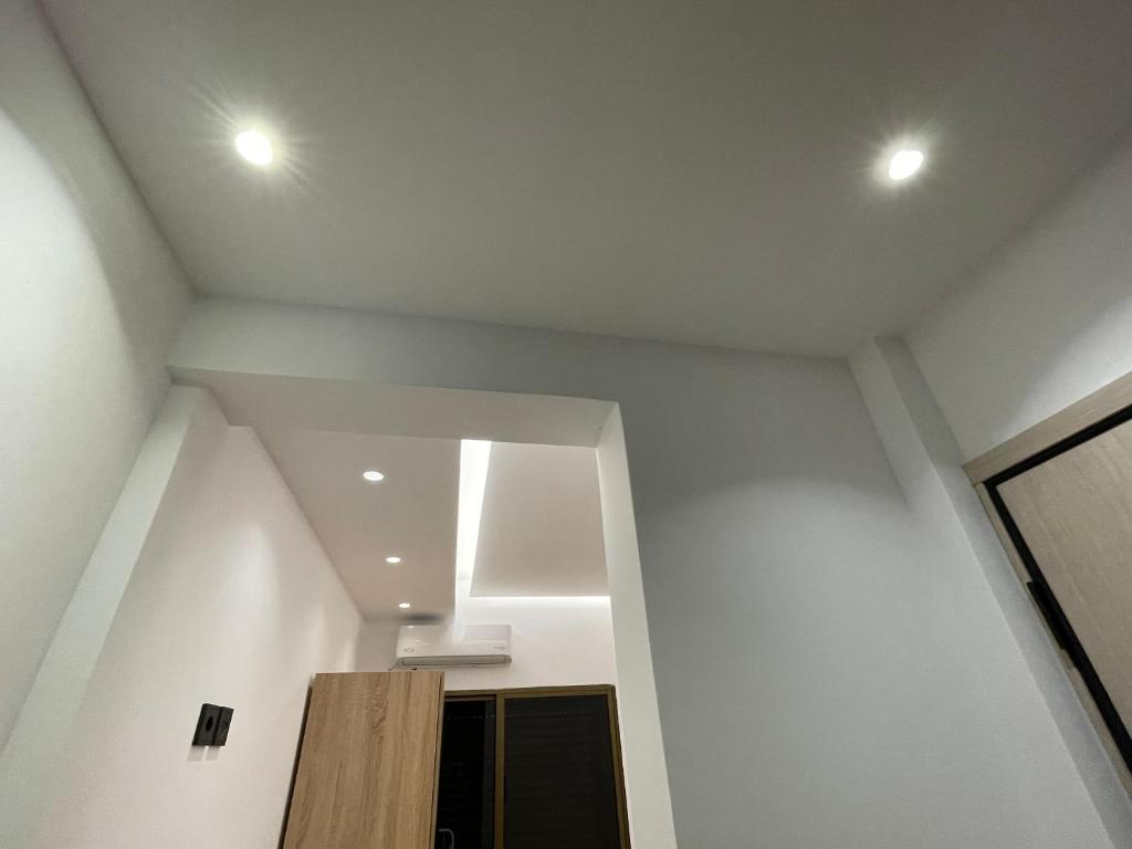 a room with white walls and a ceiling with lights at Ntina's Room in Nea Potidaea