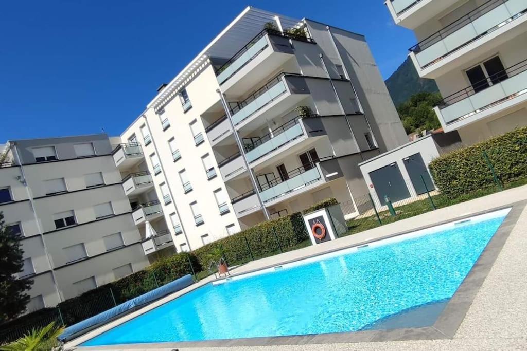 a swimming pool in front of a building at Superbe appartement en résidence avec piscine. in Albertville