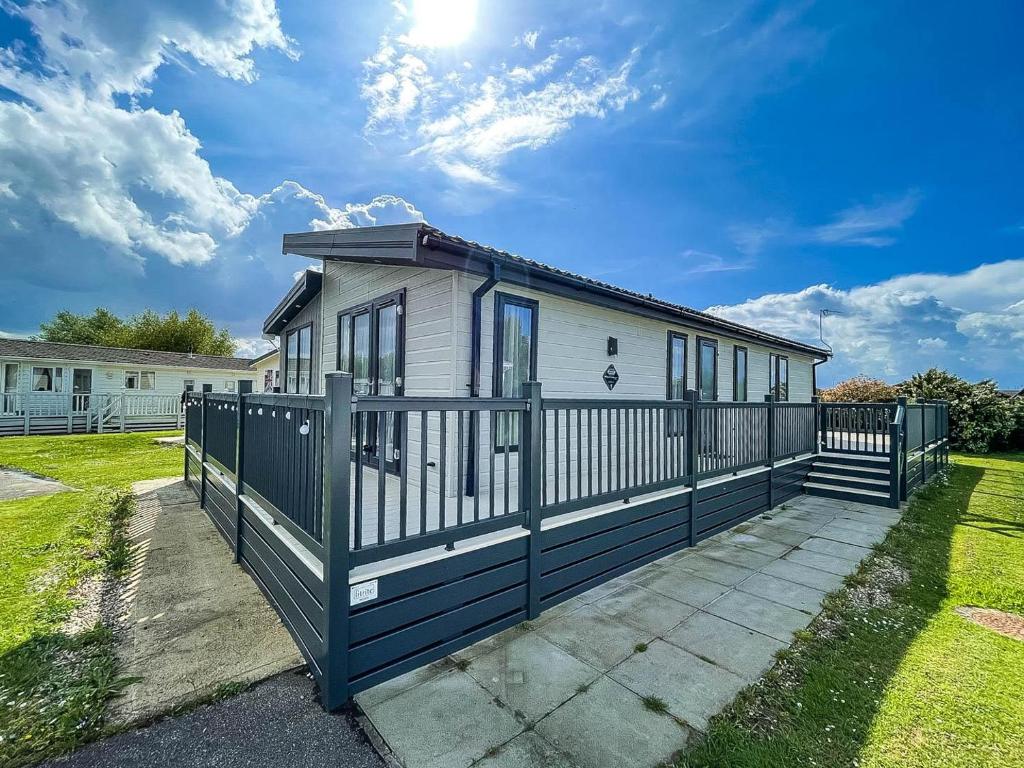 ein Haus mit einem Tor und einem Zaun in der Unterkunft Stunning Lodge With Decking Nearby Hunstanton Beach, Sleeps 6 Ref 23215k in Hunstanton