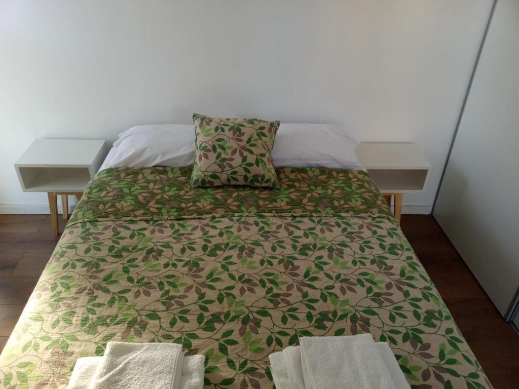 1 dormitorio con 1 cama con manta verde y marrón en Alquiler temporario con pileta y Sum en Córdoba