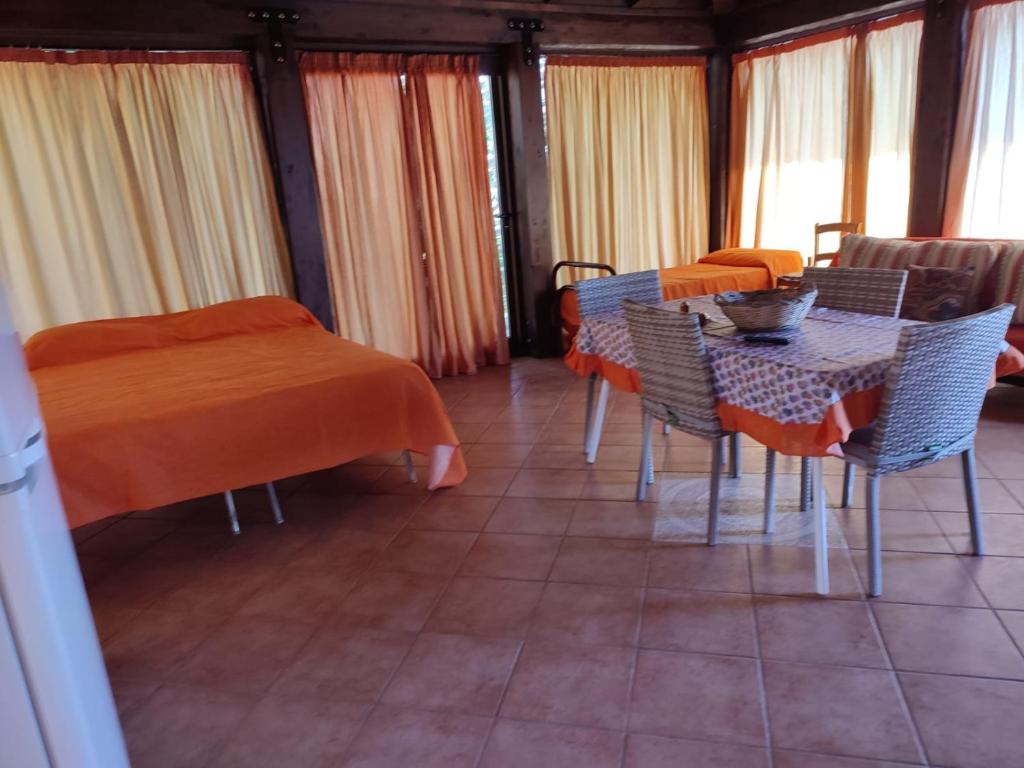 a dining room with a table and chairs and windows at villa solare in Castellammare del Golfo