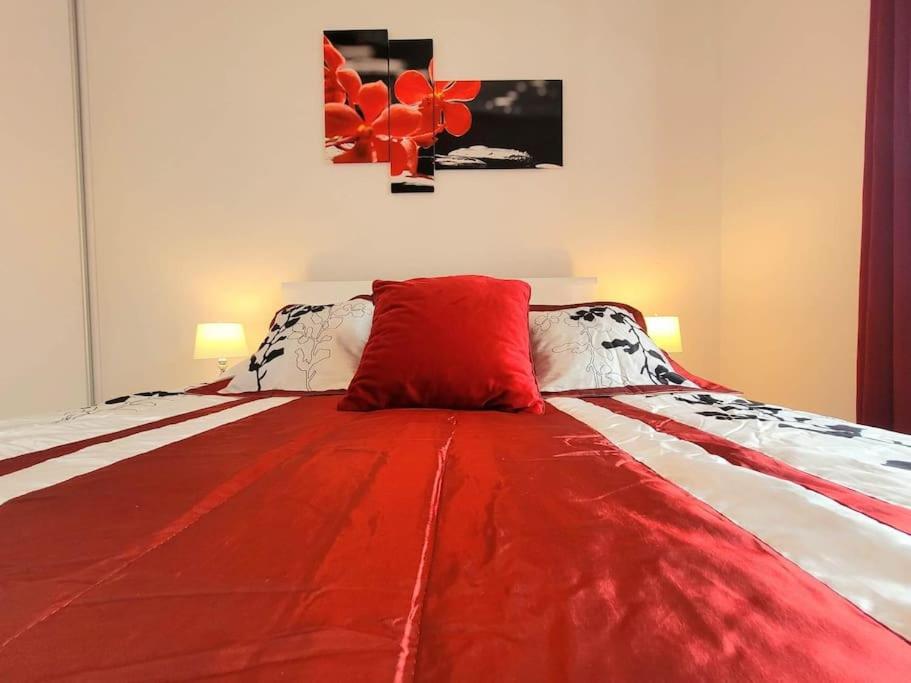 Una cama con una manta roja encima. en Apartment Sophie 3 rooms, 2 bathrooms, 8 persons, en Cracovia