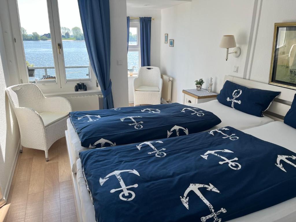 um quarto com 2 camas com edredões azuis e uma janela em Hotel Ambiente em Brake