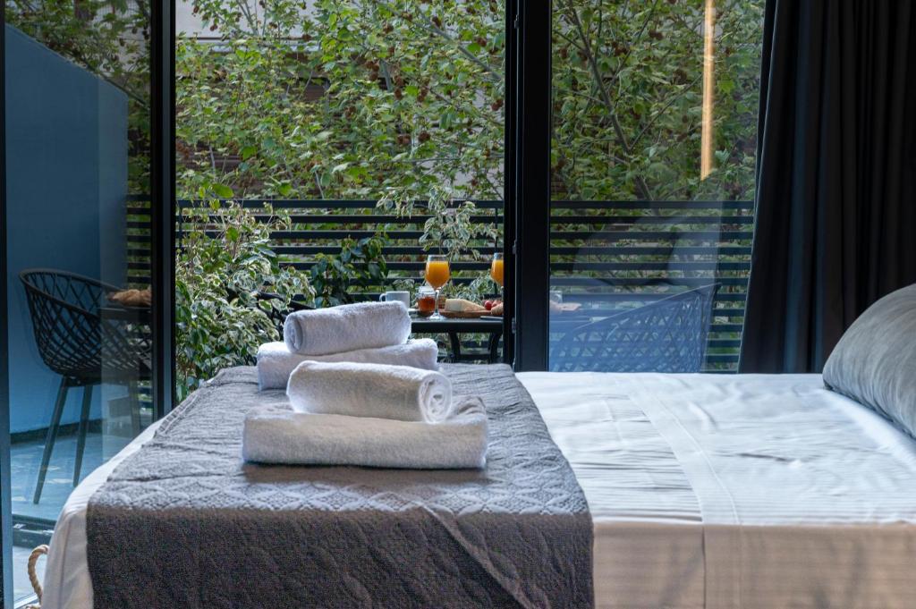 a group of towels sitting on top of a bed at Furla Suites Athens in Athens