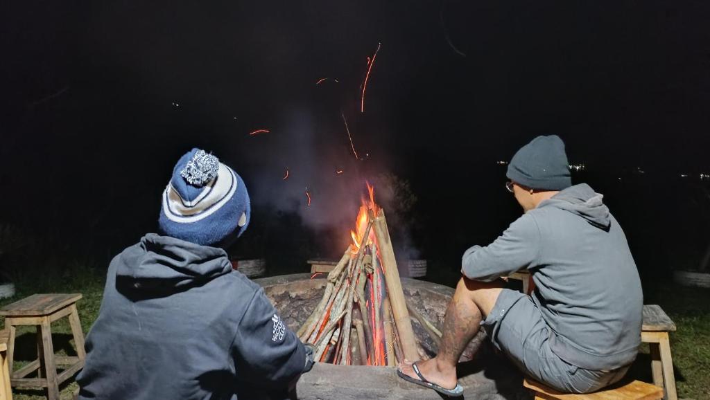 a group of three people sitting around a fire at Kintamani Adventure 'Explore the Unseen' bring your own tent in Kintamani