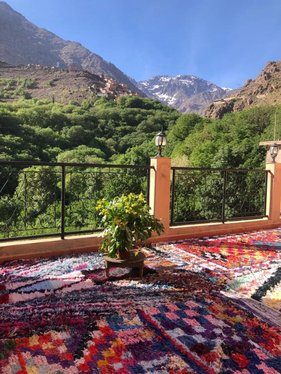 - un tapis sur un balcon avec vue sur la montagne dans l'établissement Dar Amadine, à Imlil