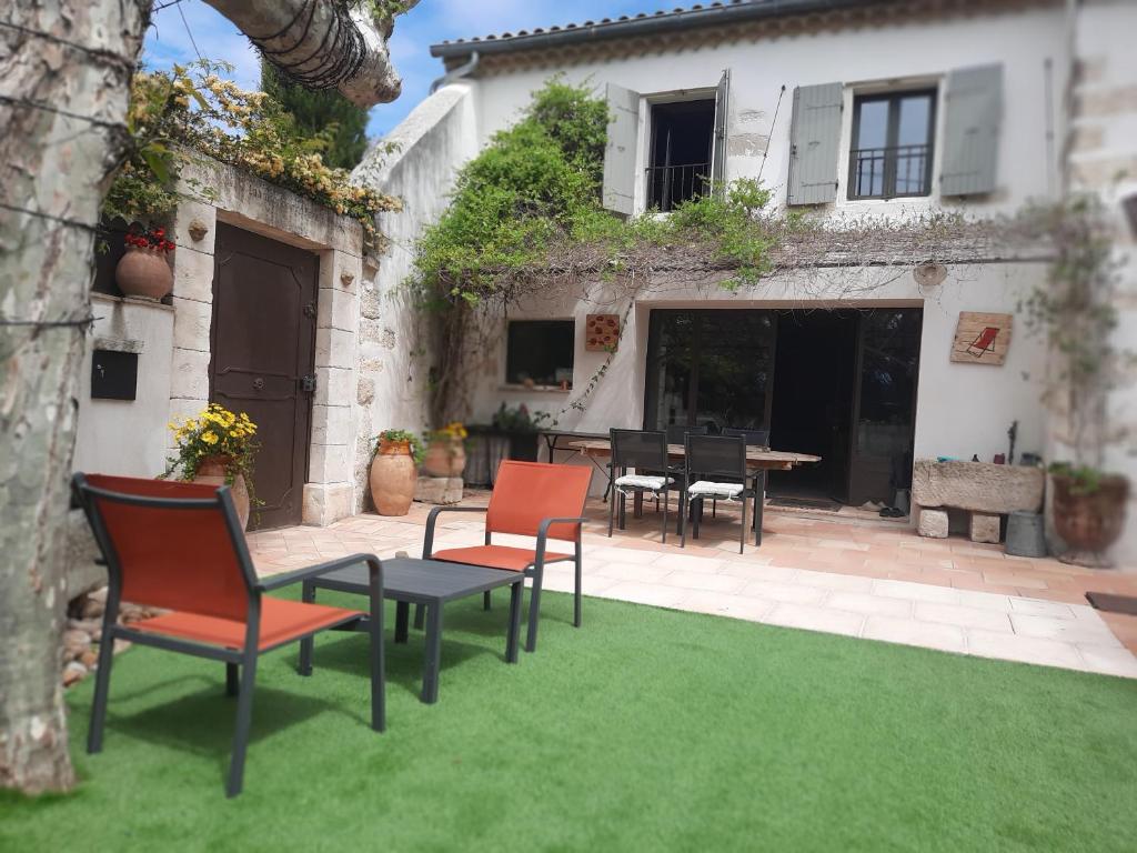 a patio with chairs and a table in front of a house at Mas" La Maison de mon Père " Proche AVIGNON à PUJAUT in Pujaut