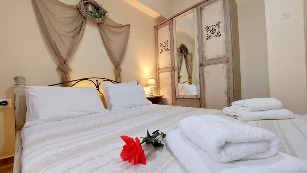 een slaapkamer met een wit bed en handdoeken bij Lourantos Studios & Apartments in Vathi