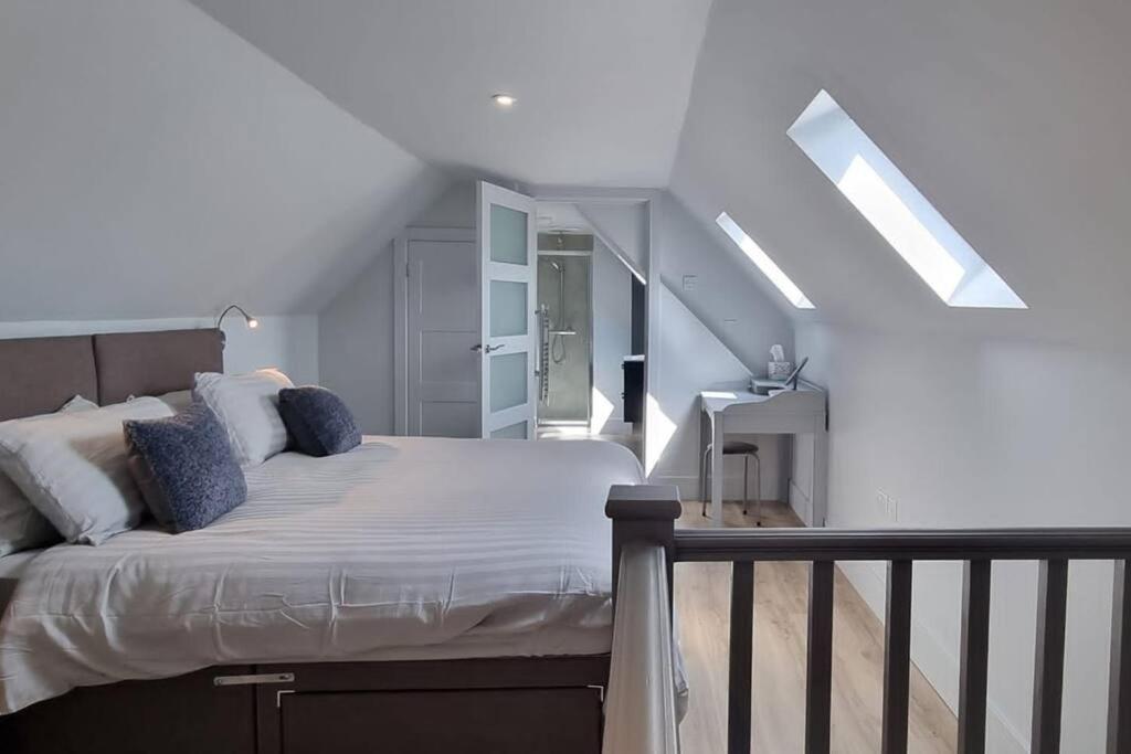 a bedroom with a bed with white sheets and blue pillows at The Nest in Coveney