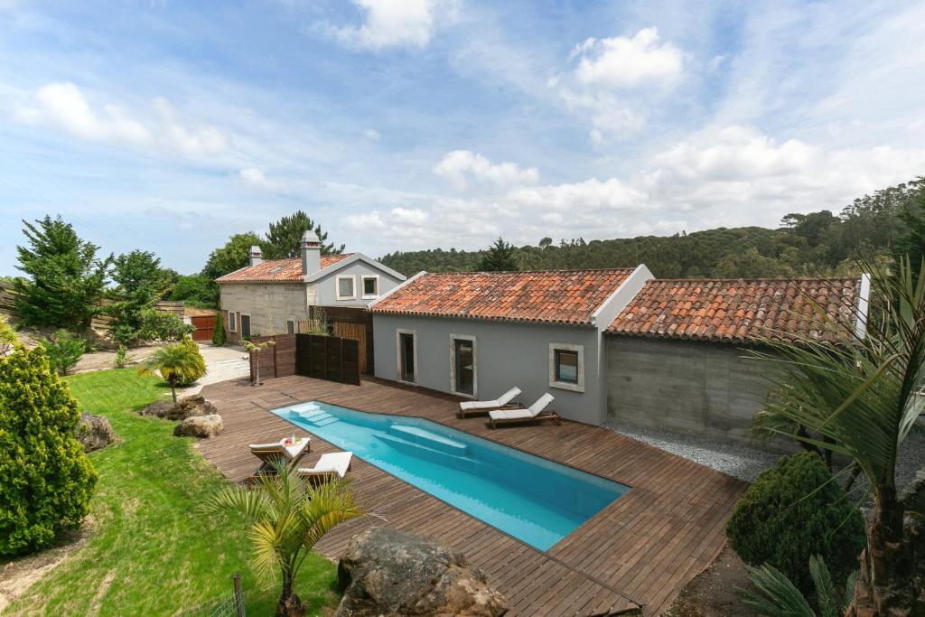 a backyard with a swimming pool and a house at Casa do Vale in Óbidos