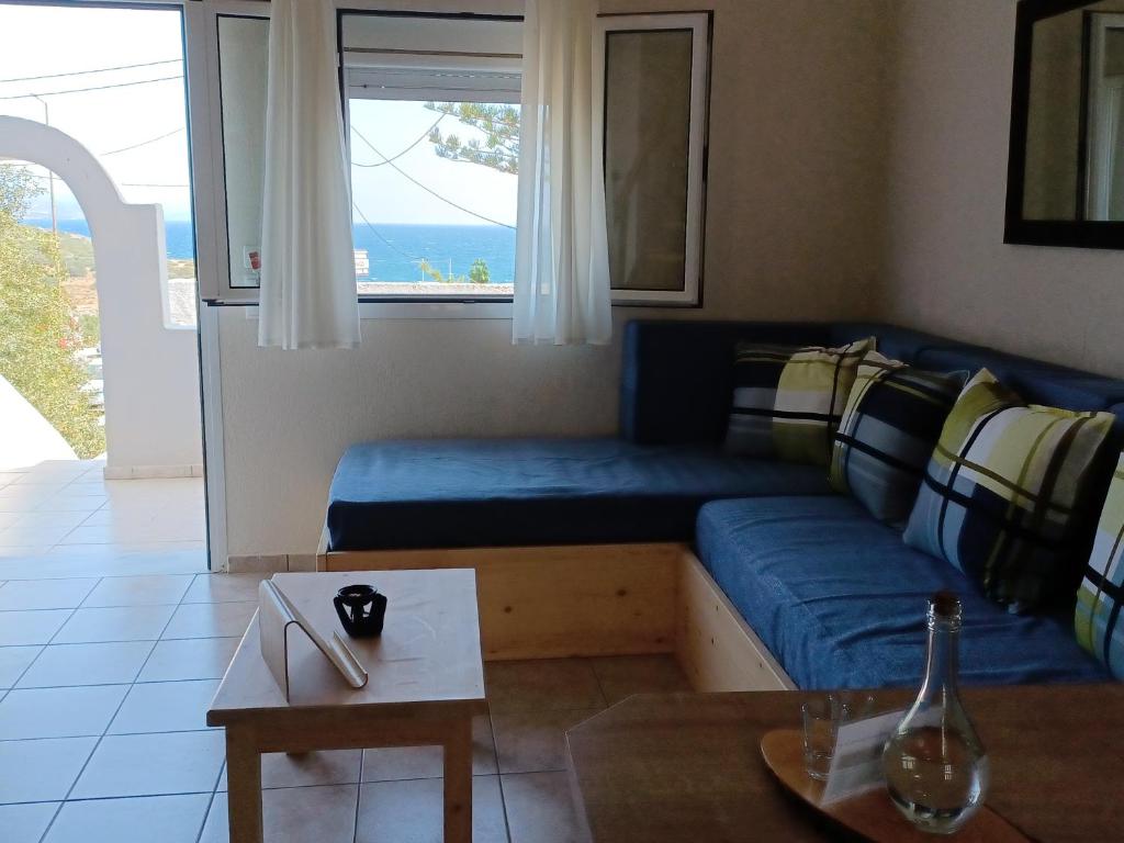 - un salon avec un canapé bleu et une table dans l'établissement Chrysoula's Paradise, à Istron