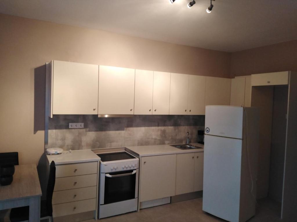 a kitchen with white cabinets and a white refrigerator at Brand new spacious studio in Itea
