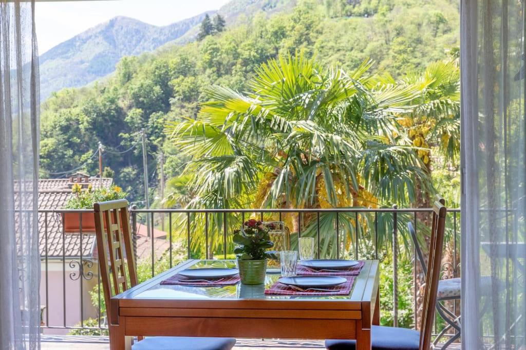 a table on a balcony with a view of a mountain at Casa Ruth Brissago in Brissago