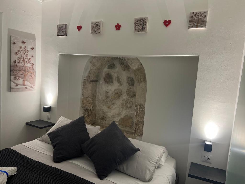a bedroom with a bed with black and white pillows at Gargallo Suite Ortigia in Syracuse