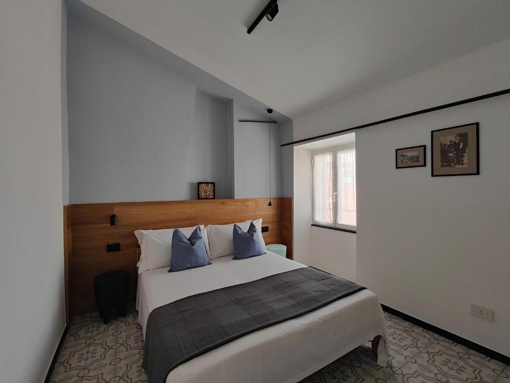 a bedroom with a large white bed with blue pillows at Casa Aicardi in Alassio