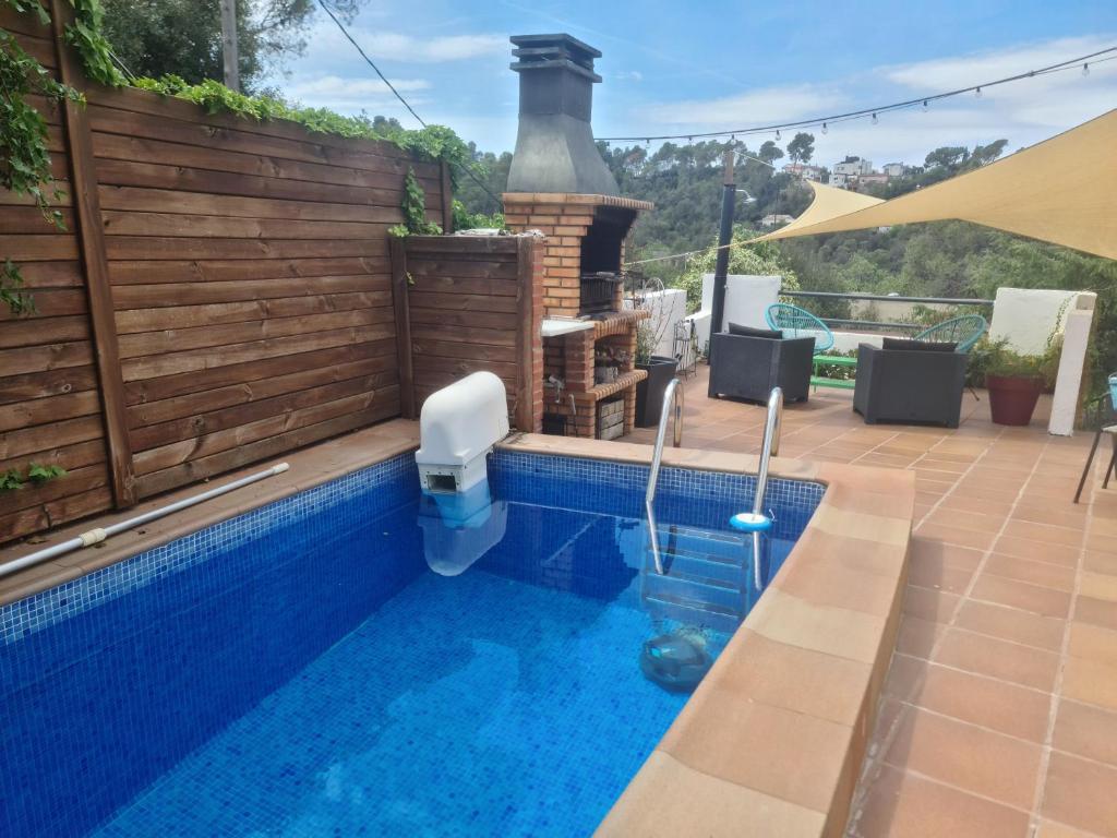 una piscina con chimenea en el patio trasero en Nature Oasis near Barcelona with swimming pool, en Sant Cugat del Vallès