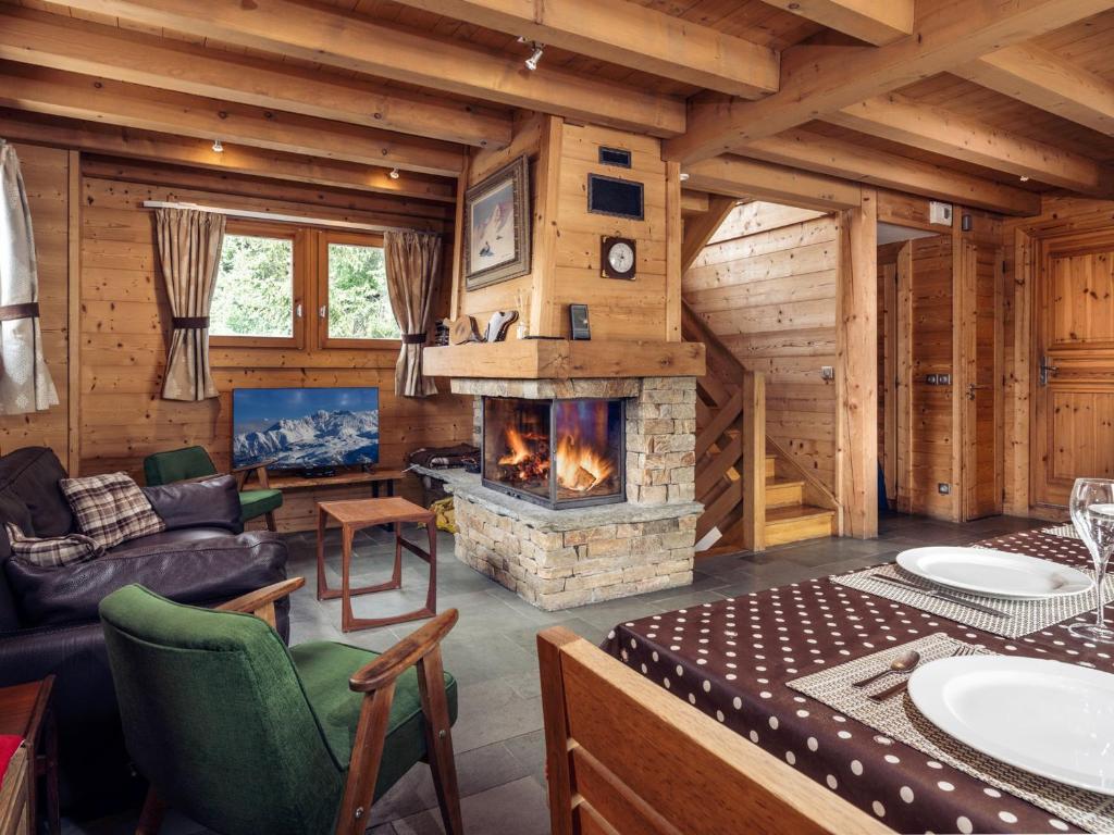 a living room with a fireplace in a log cabin at Chalet Méribel, 5 pièces, 8 personnes - FR-1-688-18 in Méribel