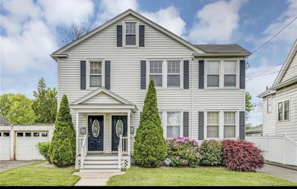 a white house with a black door at Secret Oasis In The Heart Of Hartford in Hartford